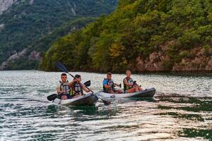 A group of friends enjoying having fun and kayaking while exploring the calm river, surrounding forest and large natural river canyons photo