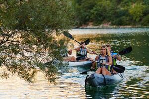 A group of friends enjoying having fun and kayaking while exploring the calm river, surrounding forest and large natural river canyons photo