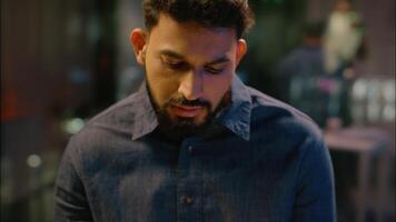 Thoughtful thinking Indian man guy think businessman working at night evening office Arabian male business employer manager analyst writing notes consider task ideas planning create write in notebook video