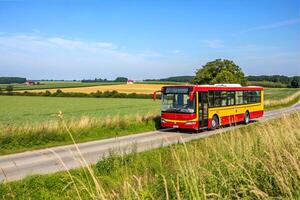 A regular intercity bus travels through a field along the route photo