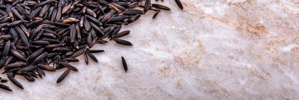Close-up view of raw wild rice spilled on marble surface for culinary background photo