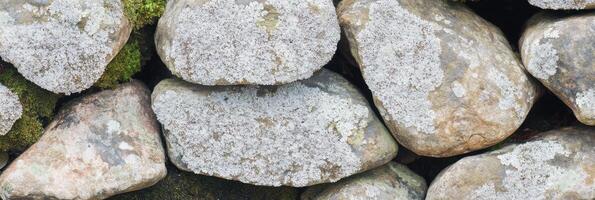 Lichen-covered stones forming a natural weathered rock wall photo