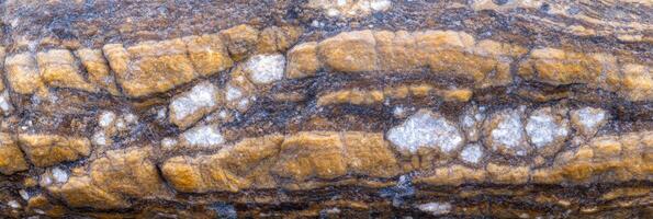 Textured natural stone surface with orange and white striations for background design photo