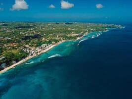 Above shot of coastline in Bali with waves in ocean, drone view photo