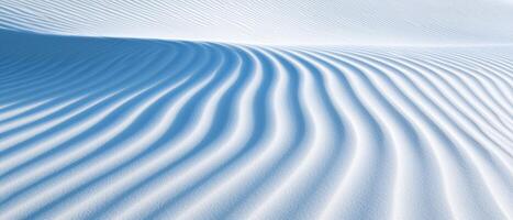 White sand dune with wind patterns forming a natural textured surface. The soft ridges create a beautiful desert landscape with light and shadow effects. photo