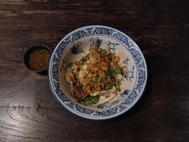 Top view of dried rice porridge with stewed pork mixed garlic on wood texture background photo