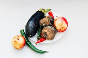 spoiled vegetables and fruits arranged on a plate with a clean background for a healthy meal photo