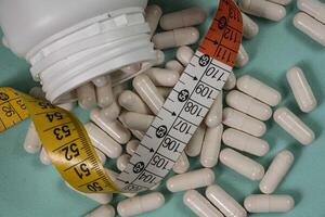 A bottle of pills and a measuring tape photo