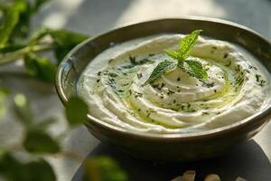 Creamy avocado dip with yogurt, garlic, and mint in a bright ceramic bowl photo