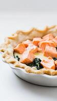 Beautiful salmon pie with spinach and lemon cream in a sleek pie pan on a clean backdrop photo