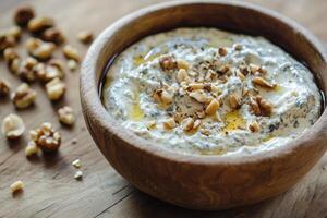 Delicious gorgonzola dip garnished with assorted nuts and a touch of honey on rustic wooden surface photo