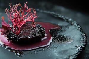 Slow-braised short rib with kombu mirin reduction and algae tuile offers a unique culinary experience photo