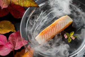 Delicately torched Arctic char with frozen yuzu mist and vibrant garnishes on a crystal plate photo