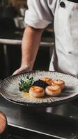 Elegant presentation of seared scallops with yuzu beurre blanc and caviar in a fine-dining kitchen setting photo