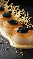 Golden-brown seared scallops with yuzu beurre blanc and black caviar on a dark backdrop photo