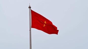 The Vietnamese flag flutters in the wind against a cloudy sky. A yellow star on a red background. video