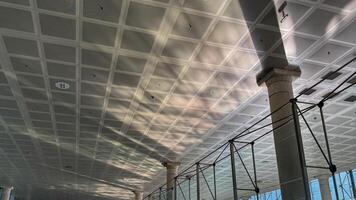 Sunlight streams through patterned ceiling onto spacious interior with shadows, architectural design, light play March 16 2025, Barcelona, Spain photo
