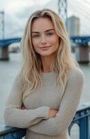 Beautiful smiling blonde woman standing on iron bridge railing photo