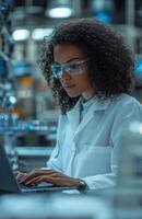 Female scientist working with laptop in modern medical laboratory setting photo
