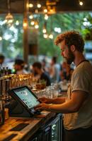 A man is using a tablet at a bar photo