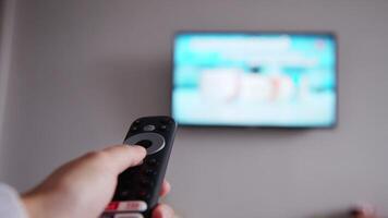 TV remote control. Handheld remote control changing channels. Concept of technological devices, close-up of human hand holding remote control and pressing buttons video