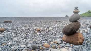 Pyramid made of stack of round stones put together at each other at stony gravel beach seacoast with copy space photo