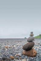 Cover page with view of pyramid made of stack of round stones put together at each other at stony gravel beach seacoast, copy space photo