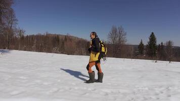 A person in yellow and black clothes standing in the snow video