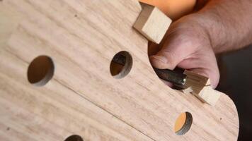 Luthier with a chisel working in the structure of a new violin video