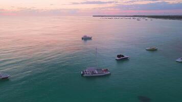 Aerial View of Catamarans and Boats Docked at Punta Cana Shoreline, Dominican Republic. Stunning Pink Sunrise Over Calm Turquoise Ocean Waters. Drone Footage. 2025 video