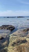 Mountain view from a rocky shore, an island in the middle of the ocean, horizon video