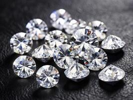 Scattered diamonds. Group of faceted diamonds on a black background. Jewels photo