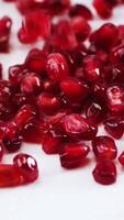 background Pomegranate seeds slowly fall to the surface texture video