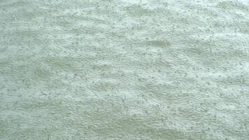 Shows water with ripples from rain impact on the sea surface. Suggesting a or interactive element. Scene is somewhat muted with a focus on the water sea texture video