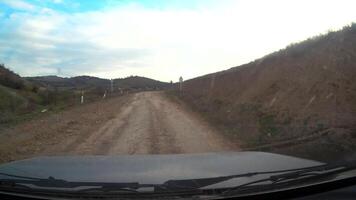 Driving a car on a dirt uneven road, view from the windshield window. High quality 4k footage video