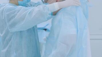 Nurse assisting surgeon and helping with gloves in operating room at hospital 2 video
