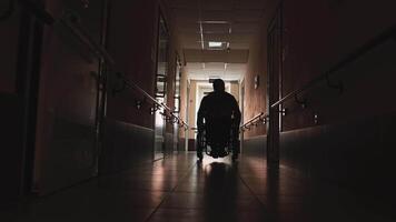 Man with disabilities in a wheelchair walking in a long hall video