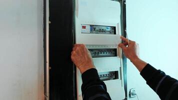 Electricians hands closing cap of electric in control panel. Electrician engineer work in electrical cabinet control. video