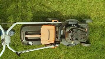 Lawn mower cutting the grass. Gardening activity. Cutting grass with petrol driven lawn mower in sunny garden. Gardener working with mower machine in the garden. Lawn mower cutting green grass 12 video