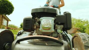 Lawn mower cutting the grass. Gardening activity. Cutting grass with petrol driven lawn mower in sunny garden. Gardener working with mower machine in the garden. Lawn mower cutting green grass 211 video