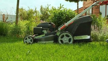 Lawn mower cutting the grass. Cutting grass with petrol driven lawn mower in sunny garden. Gardener working with mower machine in the garden. Lawn mower cutting green grass 28 video