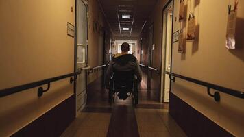 Man with disabilities in a wheelchair walking in a long hall 2 video