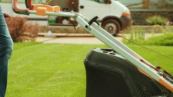 Lawn mower cutting the grass. Gardening activity. Cutting grass with petrol driven lawn mower in sunny garden. Gardener working with mower machine in the garden. Lawn mower cutting green grass 8 video