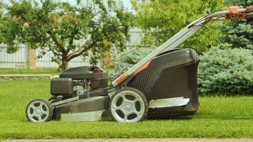 Lawn mower cutting the grass. Gardening activity. Cutting grass with petrol driven lawn mower in sunny garden. Gardener working with mower machine in the garden. Lawn mower cutting green grass 5 video