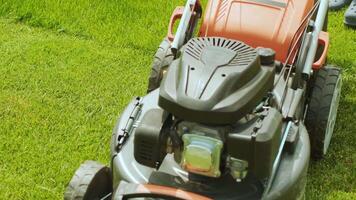 Lawn mower cutting the grass. Gardening activity. Cutting grass with petrol driven lawn mower in sunny garden. Gardener working with mower machine in the garden. Lawn mower cutting green grass 9 video