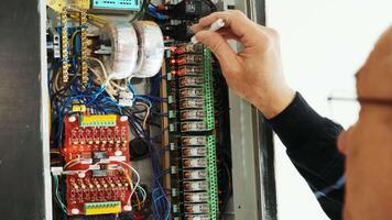 Electricians hands testing current electric in control panel. Electrician engineer work tester measuring voltage and current of power electric line in electical cabinet control. video