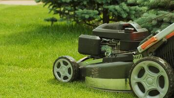 Lawn mower cutting the grass. Gardening activity. Cutting grass with petrol driven lawn mower in sunny garden. Gardener working with mower machine in the garden. Lawn mower cutting green grass 10 video