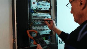 Electricians hands testing current electric in control panel. Electrician engineer work tester measuring voltage and current of power electric line in electical cabinet control. 6 video
