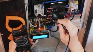 Electricians hands testing current electric in control panel. Electrician engineer work tester measuring voltage and current of power electric line in electical cabinet control. 3 video
