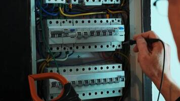 Electricians hands testing current electric in control panel. Electrician engineer work tester measuring voltage and current of power electric line in electical cabinet control. 8 video